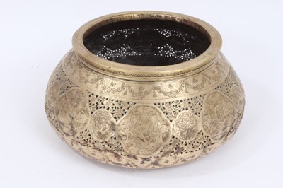 Lot 1023 - 18th/19th century Qajar pierced and tooled brass bowl, of compressed form, engraved with figural reserves, 23cm diameter