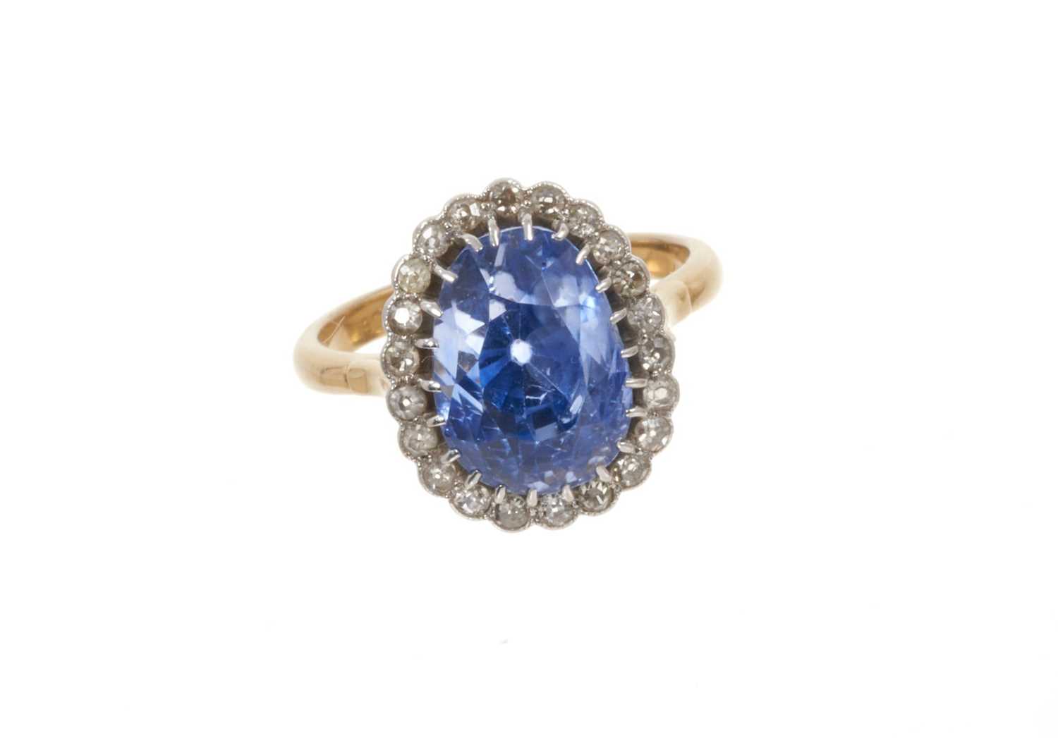 Lot 699 - Sapphire and diamond cluster ring with a pear-cut cornflower blue sapphire measuring approximately 12.1mm x 8.8mm x 11.3mm surrounded by a border of old cut and single cut diamonds in platinum sett...