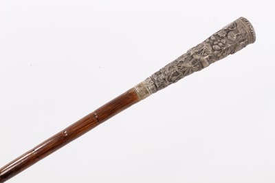 Lot 1050 - 19th century Anglo-Indian white metal and cane walking stick, the tapering handle embossed with continuous frieze of animals in a jungle, 80cm long