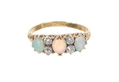 Lot 765 - Late Victorian opal and diamond ring with three oval cabochon opals interspaced by four old cut diamonds in gold claw setting with pierced shoulders on 18ct gold shank, ring size Q.