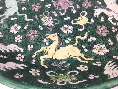 Lot 105 - Antique Chinese Qing famille verte porcelain dish painted with horses, precious objects, waves and scrolls, 33cm diameter