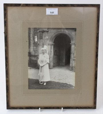 Lot 141 - H.M.Queen Mary, signed presentation portrait photograph of The Queen wearing a white outfit including matching hat and umbrella outside a church door, signed in ink ' Mary R Sept. 1937' in glazed f...