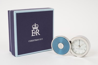 Lot 157 - H.M.Queen Elizabeth II 2015 Royal Household Christmas present, silver plated and enamelled travelling alarm clock with crowned ERII cipher to centre 4.8 cm diameter, quartz movement with operating...