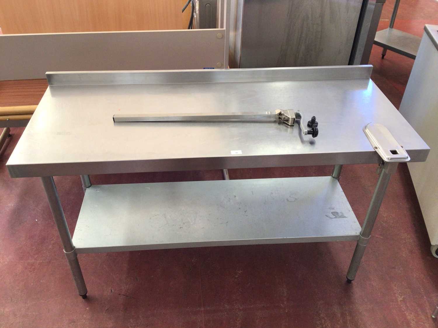 Lot 48 - A wall mounted stainless steel preparation bench, with shelf under and fitted can opener, 1500 mm