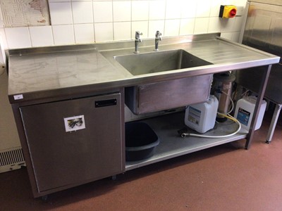Lot 57 - A stainless steel single bowl sink unit, with two taps, integral cabinet and shelf under, 1800 mm