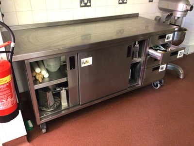 Lot 66 - A Moffat stainless steel wall standing kitchen base unit, with twin sliding door cupboard and four drawers, on castors, 1800 mm