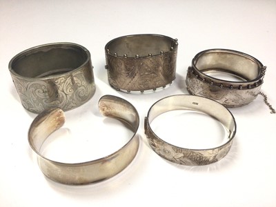 Lot 17 - Victorian silver hinged bangle, 1970s silver bangle, two other white metal bangles and contemporary silver torque bangle (5)