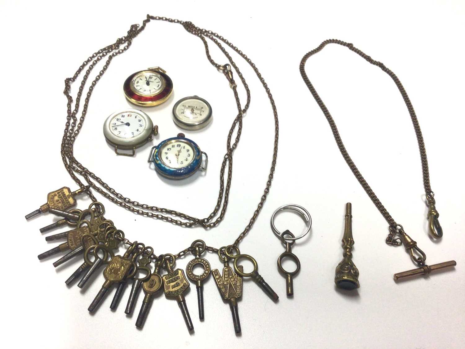 Lot 26 - Collection of watching winding keys on long chain, one other watch chain, seal/fob key, vintage silver enamelled watch and three others