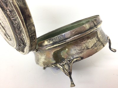 Lot 131 - Edwardian silver oval jewellery box on four legs with relief decoration to lid depicting a couple
