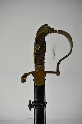 Lot 945 - Imperial German Artillery Officers sabre with brass stirrup hilt, lions head pommel, crossed cannon langet, curved etched blade decorated with military trophies, in black painted steel scabbard