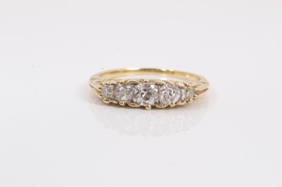Lot 216 - Diamond five stone ring with five graduated brilliant cut diamonds in carved scroll setting