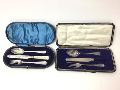 Lot 232 - Edwardian silver christening knife, fork and spoon set in fitted case and a similar 1920s silver trio, also in fitted case