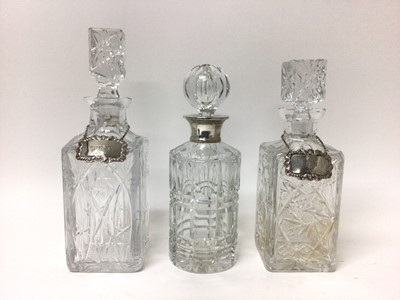 Lot 191 - Two square cut glass decanters with silver labels, and another decanter with silver collar