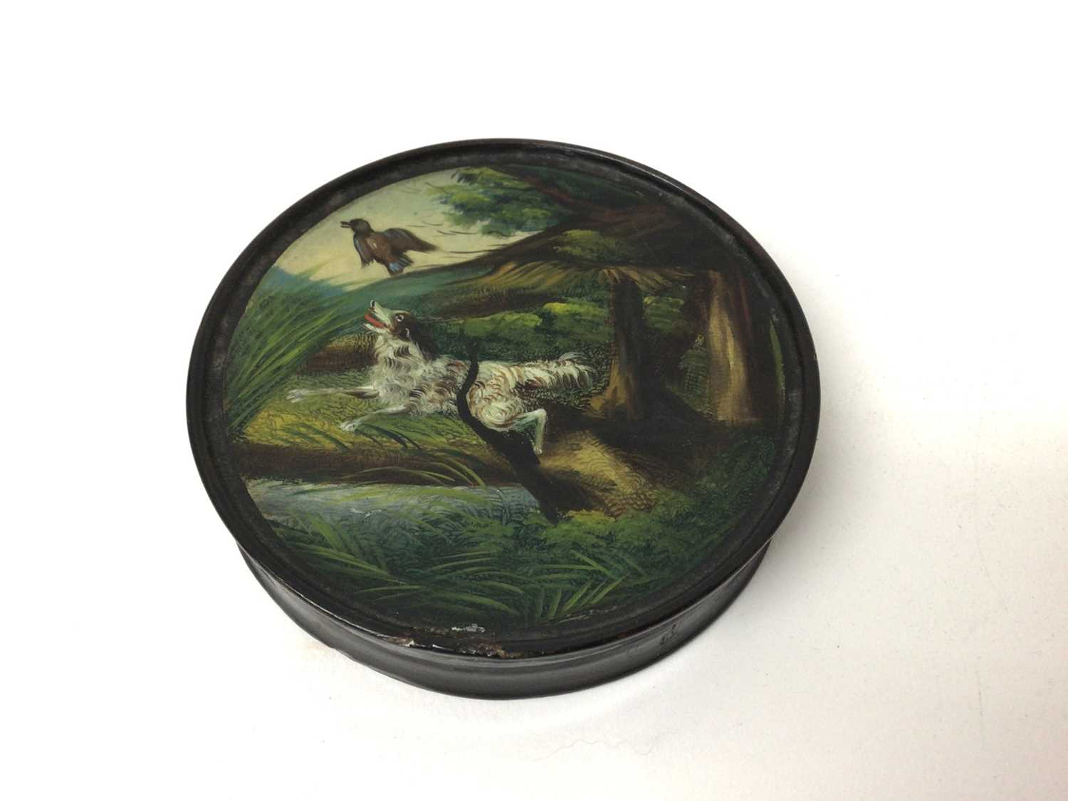 Lot 208 - Regency circular papier-mâché erotic table snuff box of circular form with painted dog chasing a duck to lid and erotic scene to the interior 9 cm diameter