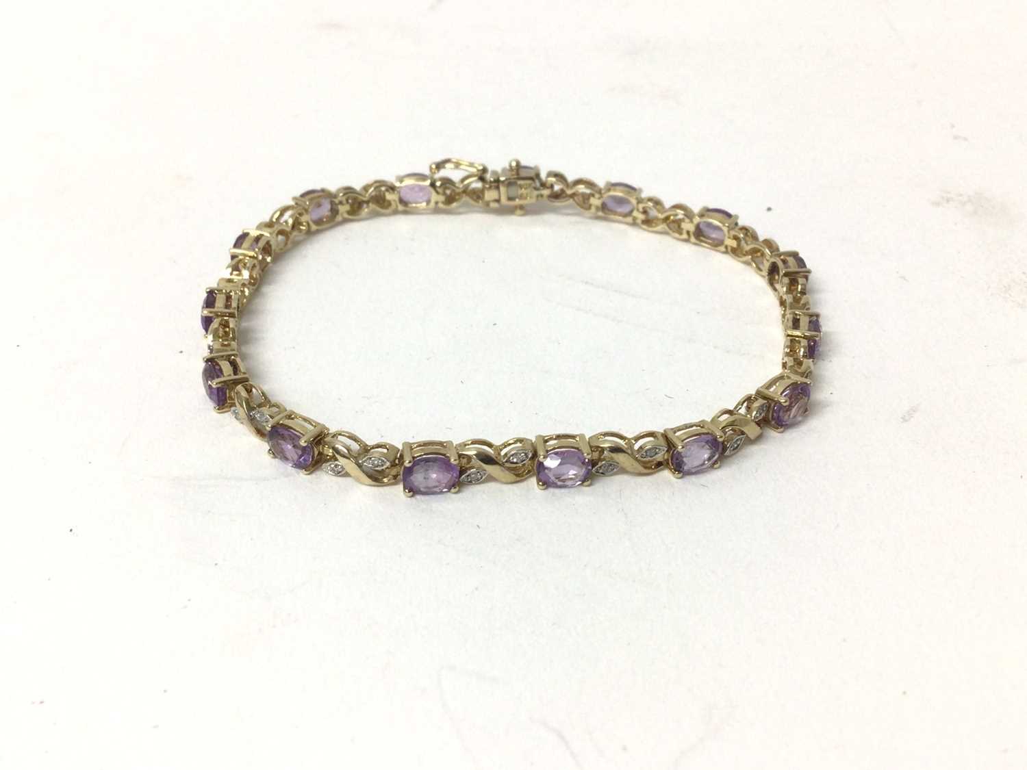 Lot 213 - Amethyst and diamond bracelet with oval mixed cut amethysts and single cut diamonds in 9ct gold setting, 18.5cm length.