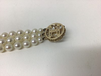 Lot 215 - Cultured pearl bracelet with a triple strand of 6mm cultured pearls on a 9ct gold clasp, 18cm.