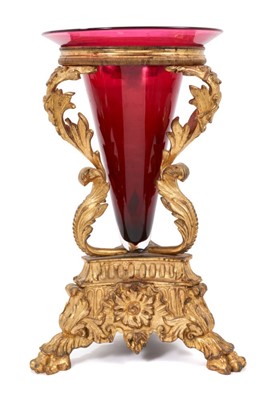 Lot 744 - 19th century ormolu table centrepiece with ruby glass trumpet, raised on elaborate acanthus supports and triform spread base on lion paw feet, 29cm high