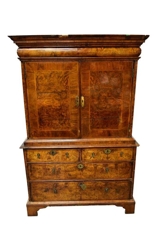 Lot 1404 - Early 18th century walnut veneered secretaire chest on chest, the top with frieze drawer, fitted interior with pigeon holes and drawers enclosed by two doors, the base with two short and two long d...