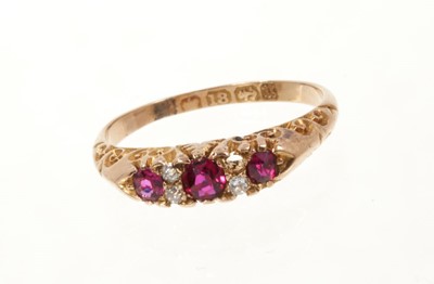 Lot 449 - Victorian ruby and diamond ring with three round mixed cut rubies and four old cut diamonds in carved gold setting on 18ct gold shank.