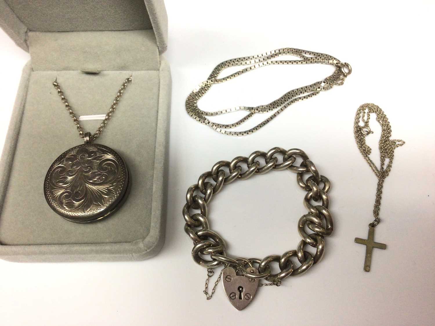 Lot 9 - Heavy silver curb link bracelet with padlock clasp, silver locket on chain, cross pendant on chain and a silver box link chain