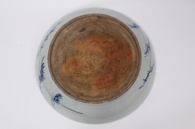 Lot 19 - A 19th century Chinese porcelain charger, painted in underglaze blue and red with lotus flowers