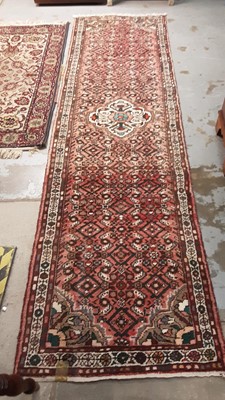 Lot 1061 - Eastern runner with geometric decoration on red ground, 292cm x 80cm, together with another with floral decoration, 158cm x 86cm