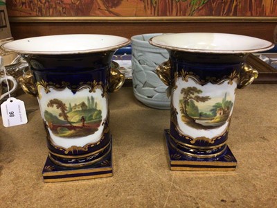 Lot 104 - Pair of 19th century English porcelain twin handled vases on square bases, painted with landscape scenes on gilt and cobalt ground, 13.5cm high