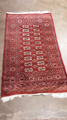 Lot 1205 - Eastern rug with 20 central medallions on red ground, 160cm x 92cm