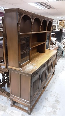 Lot 1208 - Old Charm oak two height dresser with open shelves and two cupboards above enclosed by leaded glazed doors, four drawers and four linenfold panelled doors below, 184cm wide, 48.5cm deep, 183cm high