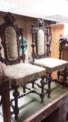 Lot 1210 - Three late Victorian carved oak high back chairs with mask decoration, green upholstered seats and backs on fluted turned front legs joined by stretchers