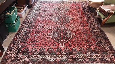 Lot 1217 - Eastern rug with three central medallions and geometric decoration on red, brown and green ground, 291cm x 209.5cm