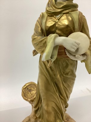 Lot 23 - An early 20th century Royal Worcester figure of a musician, modelled in gilt as a lady with a drum, signed Hadley with puce mark to base and number 1567