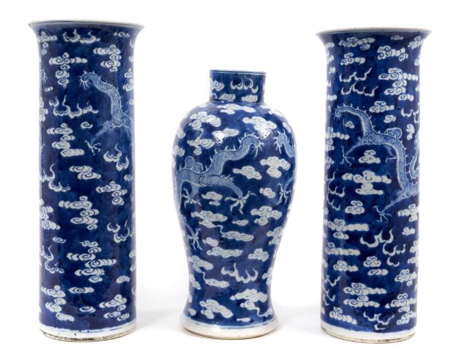 Lot 37 - A garniture of late 19th century Chinese blue and white porcelain vases, each decorated with dragons chasing a flaming pearl amongst stylised clouds, character marks, 36cm and 31.5cm high