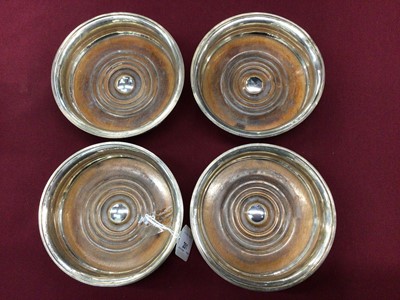 Lot 201 - Four George III silver bottle coasters