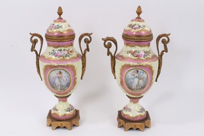 Lot 76 - A pair of 19th century Sevres style ormolu-mounted twin-handled vases, decorated with figural and landscape panels on a floral-decorated pink and pale yellow ground, interlaced L marks to bases, 38...