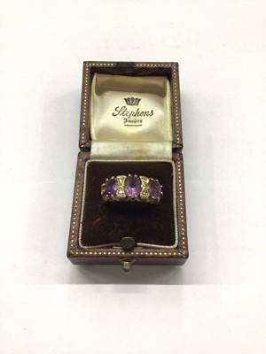 Lot 814 - 9ct gold amethyst three stone ring interspaced with diamonds, size M½