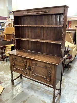 Lot 1017 - 1920's/30's oak two height dresser with open shelves above  two geometric panelled doors below on bobbin turned and block legs, 139cm wide, 46cm deep, 194cm high