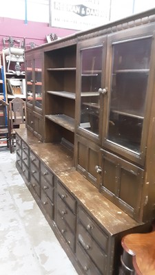 Lot 1026 - Ercol three section two height bookcase with open shelves, cupboards and glazed doors above and numerous drawers below, total width 295cm, 50cm deep, 197cm high