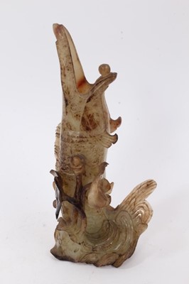 Lot 790 - Chinese russet jade carving of a pike in waves, 20cm high, together with carved jade snuff bottle and stopper and a carving of a fruit. (3)