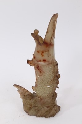 Lot 790 - Chinese russet jade carving of a pike in waves, 20cm high, together with carved jade snuff bottle and stopper and a carving of a fruit. (3)