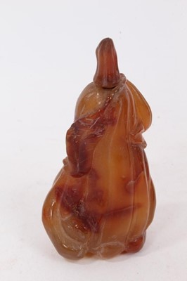 Lot 790 - Chinese russet jade carving of a pike in waves, 20cm high, together with carved jade snuff bottle and stopper and a carving of a fruit. (3)