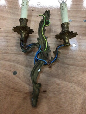 Lot 59 - A pair of gilt metal two-branch wall lights of scrolling acanthus form, 45cm high including bulbs