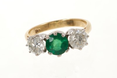 Lot 472 - Emerald and diamond three stone ring with a round mixed cut emerald estimated to weigh approximately 0.85cts flanked by two round brilliant cut diamonds, all in claw setting on 18ct gold shank. Est...