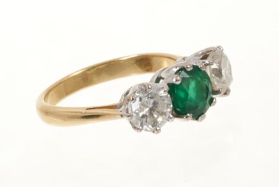 Lot 472 - Emerald and diamond three stone ring with a round mixed cut emerald estimated to weigh approximately 0.85cts flanked by two round brilliant cut diamonds, all in claw setting on 18ct gold shank. Est...