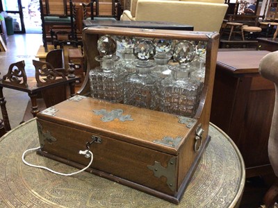 Lot 119 - Edwardian oak three-bottle tantalus with silver plated mounts and cigar drawer (key present), 34cm wide