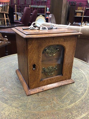 Lot 121 - A small oak two drawer cabinet with glass front and brass handles (key present), 21cm high x 21cm wide