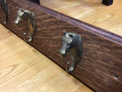 Lot 128 - Early 20th century oak coat rail with brass horse head hooks, 90cm long