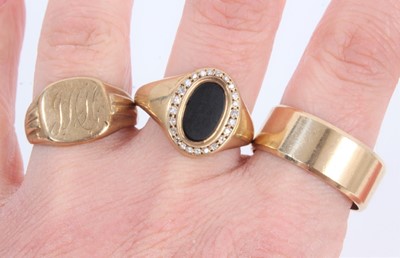 Lot 851 - 9ct gold wide band wedding ring, 9ct gold signet ring with engraved initials and one other 9ct gold oval black onyx signet ring with diamond border (3)