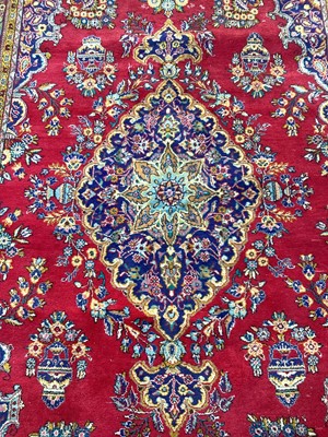 Lot 1139 - Eastern rug with central medallion on red and blue ground, 338cm x 212cm