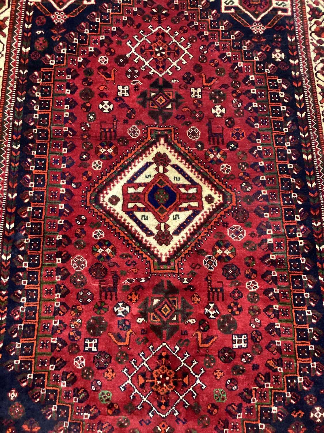 Lot 1142 - Eastern rug with geometric decoration and central medallion on red, blue and cream ground, 250cm x 161cm